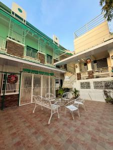 伊洛伊洛Chez Mathilds的建筑物前有桌椅的露台