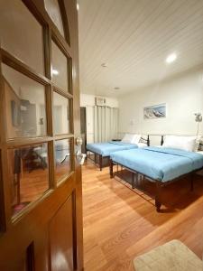 伊洛伊洛Chez Mathilds的两张床在铺有木地板的房间里