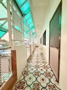 伊洛伊洛Chez Mathilds的走廊设有瓷砖地板和窗户