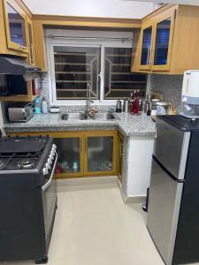 una cocina con fregadero y estufa en Casa amarilla, en Cumayasa Kilómetros 4 1/2