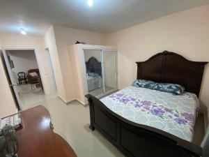 Un dormitorio con una cama, una cómoda y una mesa. en Casa amarilla, en Cumayasa Kilómetros 4 1/2