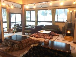 a living room with a couch and a table at わくわく自然体験の宿ゲストハウス山楽 in Itoigawa +79 photos