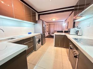uma cozinha com máquina de lavar e secar roupa em Cedar Square Apartment em Trevallyn