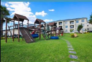 Cedar Square Apartment في Trevallyn: ملعب مع زحليقة في حديقة