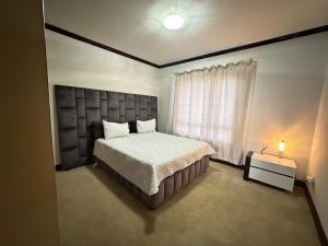 um quarto com uma cama grande e uma janela em Cedar Square Apartment em Trevallyn