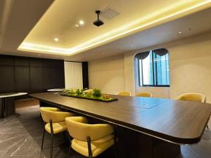 a conference room with a large wooden table and yellow chairs at Skyline Riverview Apartments in Chongqing