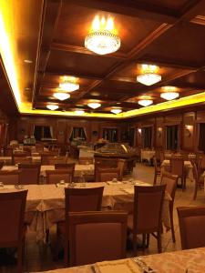 a dining room with tables and chairs and chandeliers at Val Del Rio in Fiumalbo