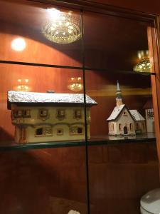 a model of a house and a church on a glass shelf at Val Del Rio in Fiumalbo