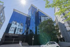 a blue building with a car parked in front of it at Cheongju The City Hotel in Cheongju