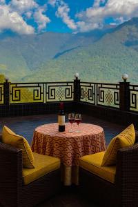 a table with two glasses of wine on a balcony at Hotel Yeasel near Ridge Park Gangtok - A Prime location property #best rated #terrace #banquet #balcony view #parking in Gangtok