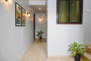 a hallway with white walls and potted plants at Via Baner Executive - Balewadi high street in Pune