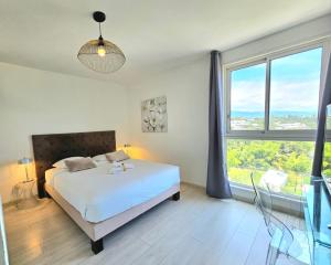 a bedroom with a bed and a large window at Horizon Magellan - Grand T3 de 86m2 - Sainte-Marie in Sainte-Marie