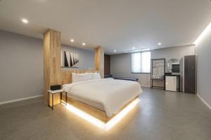 a bedroom with a large white bed with lights on it at Cheongju The City Hotel in Cheongju