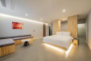 a hotel room with a bed and a couch at Cheongju The City Hotel in Cheongju