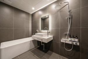 a bathroom with a sink and a bath tub at Cheongju The City Hotel in Cheongju +43 photos