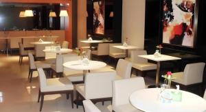 a restaurant with white tables and white chairs at Jinjiang Inn Qingdao International Exhibition Center Haier Road in Qingdao