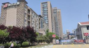 a city street with tall buildings in a city at Jinjiang Inn Qingdao International Exhibition Center Haier Road in Qingdao