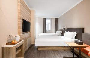 une chambre d'hôtel avec un grand lit et une télévision dans l'établissement Hanting Premium Hotel Shenzhen Sea World Subway Station, à Shenzhen