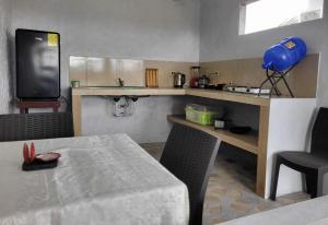 een kleine keuken met een tafel en een televisie bij Oasis Jeny 4 in Isla San Salvador +4 foto's