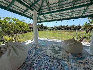 een veranda met een pergola en een kleed bij ISOLA - Surf House in Koggala