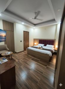 Un dormitorio con una cama, una mesa y un sofá. en Expo Residency Inn, en Jāmb