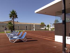 una fila de sillones blancos sentados en una terraza en Hotel Villa Carlotta, en Ragusa