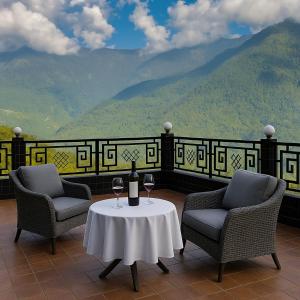 two chairs and a table with two glasses of wine at Royal Green Valley Mashobra by Naina Staycation - Mountain and valley view rooms in Shimla