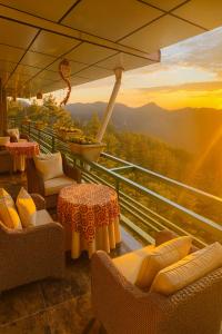 a balcony with chairs and tables and a view at Royal Green Valley Mashobra by Naina Staycation - Mountain and valley view rooms in Shimla
