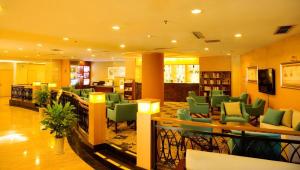 Qingdao Blue Horizon Hotel Laoshan في تشينغداو: غرفة انتظار بكراسي خضراء في مكتبة