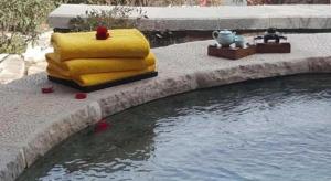 a stack of pillows next to a pool of water at Xian Huaqingyutang Hotel in Xi'an