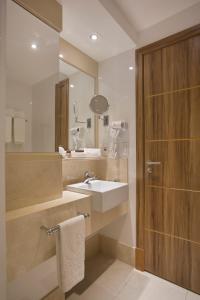 リオデジャネイロにあるホテル アトランティコ プライアのバスルーム(洗面台、鏡付)