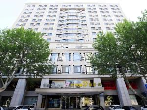 a large white building with trees in front of it at Jinjiang Inn Dalian Jiefang Road in Dalian