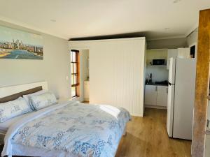 een slaapkamer met een bed en een koelkast bij Modern Rustic Backyard Studio Private & Cosy Retreat in Mount Tamborine