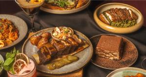 una tavola con piatti di cibo su un tavolo di Shakespeare Hotel a Hakuba