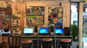 Chaweng Relax Resort في شاطئ تشاوينغ: غرفة بها أربع شاشات كمبيوتر على مكتب