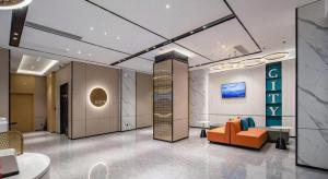 a lobby with an orange couch and a sign at City Comfort Inn Nanning Normal University Mingxiu Metro Station in Nanning