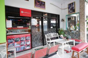 a restaurant with a table and chairs in front of it at RedDoorz Syariah near Alun Alun Balai Kota Tegal in Tegal +24 photos