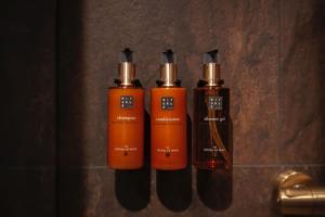 Dos botellas de champú naranja en una pared en Raitola Reindeer and Husky Farm- Panorama Lodges, en Rovaniemi