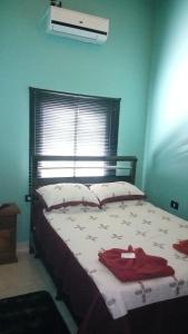 a bedroom with a bed with a red robe on it at Departamentos El Chileno in Puerto Iguazú