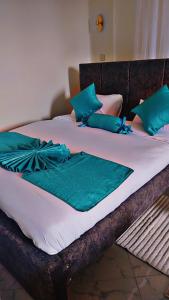ein Bett mit blauen Kissen darüber in der Unterkunft Downtown Retreat Homes in Kisii