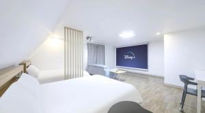 济州市The Oakra Hotel的酒店客房,配有床和投影屏幕