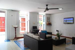 a living room with a couch and chairs and a tv at Hotel Villa Colonial By Akel Hotels in Cartagena de Indias