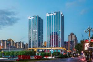 two tall skyscrapers in a city at dusk at Fortune International Hotel in Xingyin Wanfenglin Airport