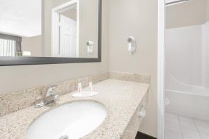 y baño con lavabo y espejo. en Super 8 by Wyndham Bay St. Louis, en Bay Saint Louis