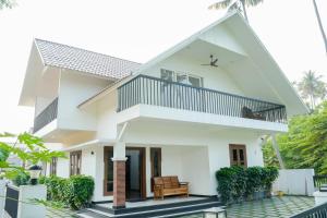 a white house with a balcony at Paradise Riviera in Ernakulam