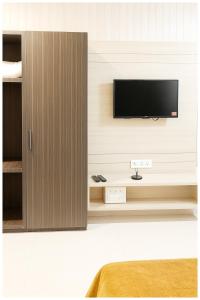 Una televisión o centro de entretenimiento en Hotel Ganga Premium Palace Near Shri Syta Narayani Maraj Temple - Lift # Room Service and Parking facilities - Fully Air conditioning Luxuary Room - Top Rated Hotel In Mathura