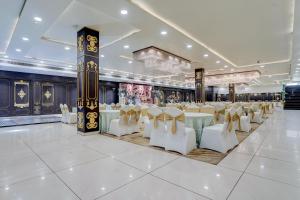 a banquet hall with white tables and white chairs at Nirvana Hotel & Banquet in Batāla