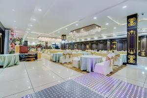 a banquet hall with white and purple tables and chairs at Nirvana Hotel & Banquet in Batāla