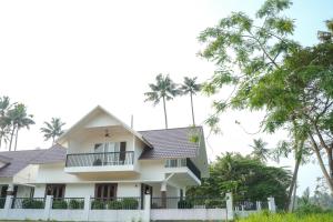 a house with palm trees in the background at Paradise Riviera in Ernakulam