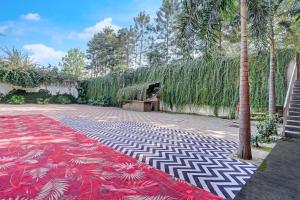a garden with a red and white carpet and trees at Nirvana Hotel & Banquet in Batāla